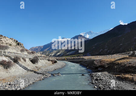 Sospensione ponte che attraversa il fiume in himalaya nepalese, in una valle di montagna nei pressi di Annapurna 3 4896 x 3264 300dpi Foto Stock