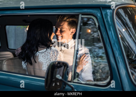 Allegro felice coppia giovane sedersi nel retro-minibus. Foto Stock