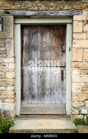 Vecchio usurato weathered porta stabile su una vecchia casa Lacock village Wiltshire, Inghilterra Regno Unito Foto Stock