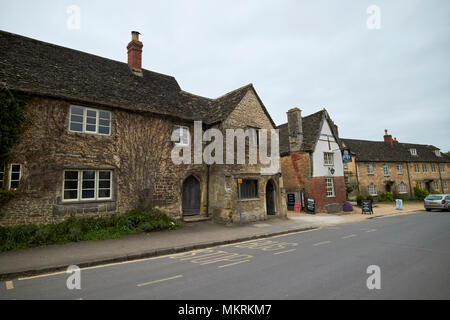Fermata bus e il george inn nel villaggio di West Street Lacock village Wiltshire, Inghilterra Regno Unito Foto Stock
