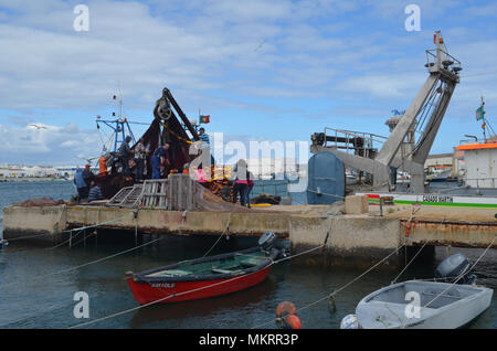 L'equipaggio di un portamonete con sciabica raccoglie le sue reti in Olhao porto di pescatori, Algarve, Portogallo meridionale Foto Stock