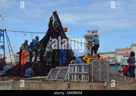 L'equipaggio di un portamonete con sciabica raccoglie le sue reti in Olhao porto di pescatori, Algarve, Portogallo meridionale Foto Stock