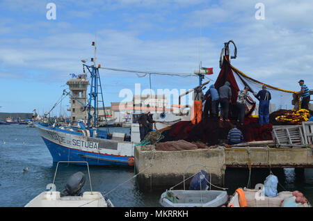 L'equipaggio di un portamonete con sciabica raccoglie le sue reti in Olhao porto di pescatori, Algarve, Portogallo meridionale Foto Stock