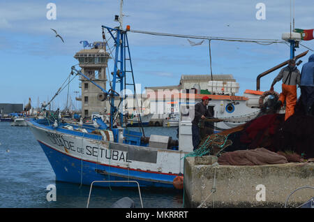 L'equipaggio di un portamonete con sciabica raccoglie le sue reti in Olhao porto di pescatori, Algarve, Portogallo meridionale Foto Stock