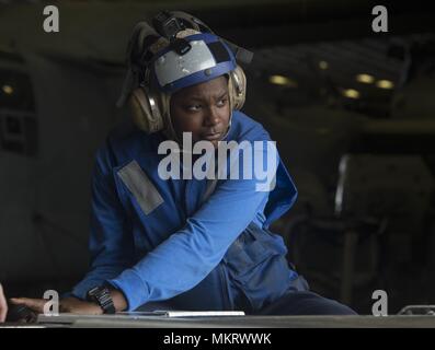 180507-N-AH771-0021 U.S. 5TH FLOTTA AREA DI OPERAZIONI (7 maggio 2018) di aviazione di Boatswain Mate (manipolazione) Airman Khalyne Jones, da Marshall, Texas, aziona un come-32A spotting dolly in hangar bay a bordo il Wasp-classe assalto anfibio nave USS Iwo Jima (LHD 7), 7 maggio 2018, 7 maggio 2018. Iwo Jima, homeported a Mayport, Fla. è sulla distribuzione per gli Stati Uniti Quinta Flotta area di operazioni a sostegno della sicurezza marittima operazioni per rassicurare gli alleati e partner e preservare la libertà di navigazione e il libero flusso di commercio nella regione. (U.S. Foto di Marina di Massa lo specialista di comunicazione 3 Foto Stock