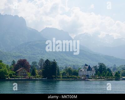 Vista del paesaggio di montagna al di là delle rive del lago di Annecy a Menton-Saint-Bernard, Francia. Foto Stock