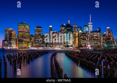 La skyline di New York in cerca di fronte al Ponte di Brooklyn Park attraverso i resti delle vecchie banchine Foto Stock