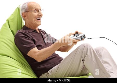 Senior seduto su una beanbag per giocare con i videogiochi isolati su sfondo bianco Foto Stock