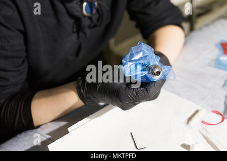 Master tattoo artist prepara gli strumenti per il tatuaggio. Foto Stock