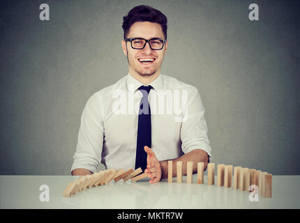 Imprenditore fermare l' effetto domino. Concetto di soluzione aziendale, strategia e intervento riuscito Foto Stock