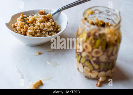 Il miele aromatizzato noci, mandorle e arachidi Dessert fragile in barattolo. Alimenti biologici. Foto Stock