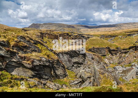 Guardando oltre il crollo del tetto della cava Rhosydd Twll Est verso vette di Cnicht e Snowdon Foto Stock