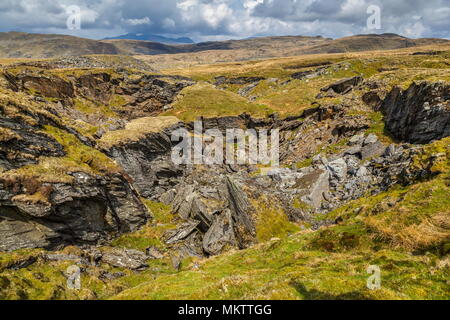 Guardando oltre il crollo del tetto della cava Rhosydd Twll Est verso vette di Snowdon Foto Stock