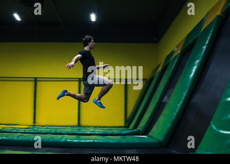 Trampoline ponticello esegue esercizi acrobatici sul trampolino Foto Stock