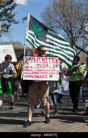 Un uomo con un segno il supporto di legalizzazione della marijuana al giorno di maggio parade e festival di Minneapolis, Minnesota, Stati Uniti d'America. Foto Stock