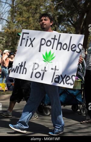 Un uomo con un segno il supporto di legalizzazione della marijuana al giorno di maggio parade e festival di Minneapolis, Minnesota, Stati Uniti d'America. Foto Stock