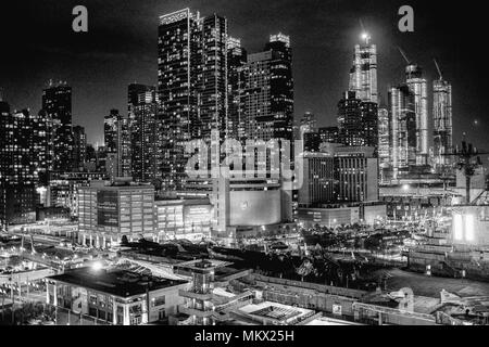 Le ore notturne vedute dello skyline di New York City, girato dal norvegese Bliss deck, compresi USS Intrepid in primo piano. Foto Stock