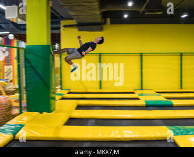 Trampoline ponticello esegue esercizi acrobatici sul trampolino Foto Stock