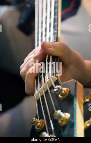 Stretta di mano suonare la chitarra acustica Foto Stock