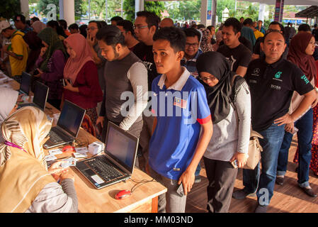 Gli elettori si vede il rivestimento fino ad una stazione di polling durante il giorno delle elezioni in Malesia. Milioni di cittadini della Malesia casted il loro voto per il xiv elezione generale il Mercoledì ed è uno dei più strettamente malese controversa elezione dall'ex Primo Ministro Mahathir Mohamed aveva aderire al partito di opposizione. Foto Stock