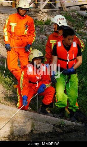 (180509) -- CHENGDU, 9 maggio 2018 (Xinhua) -- File foto scattata il 7 maggio 2009 Mostra Jiang Yuhang (L, anteriore) di prendere parte a una missione di soccorso in Miaohang Township del Comune di Shanghai, Cina orientale. Il 17 maggio 2008, Jiang, un 20-anno-vecchio highway administration dipendente, è stata extricated dai vigili del fuoco, 123 ore dopo che egli è stato intrappolato nelle macerie a quake-hit Yingxiu Township della contea di Wenchuan, a sud-ovest della Cina di provincia di Sichuan. Jiang è un superstite del 8,0-grandezza terremoto che ha colpito il Sichuan della contea di Wenchuan il 12 maggio 2008. Il sisma ha lasciato più di 69.000 morti, feriti 374,000, 18 Foto Stock