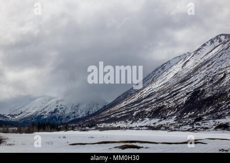 Turnagain Pass, Penisola di Kenai, Alaska. Chugach Mountains. Neve, nuvole e sole Foto Stock