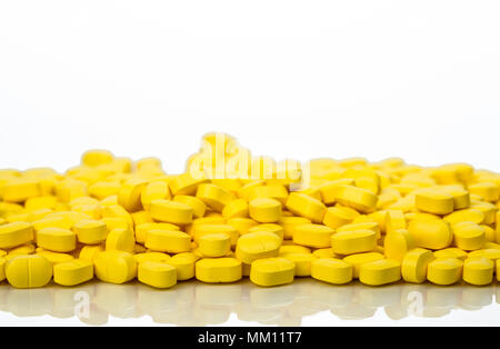Pila di giallo-ovoidale rettangolare tablet pillole isolato su sfondo bianco con copia spazio. Medicina a base di ibuprofene per il sollievo del dolore. Ho farmaceutica Foto Stock