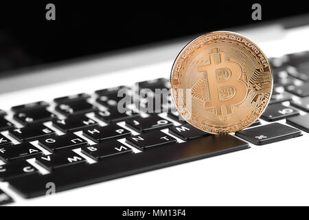 Golden bitcoin sulla tastiera del computer, primo piano. Bitcoins e denaro virtuale. Foto Stock