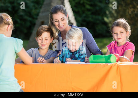 La mamma di pittura con le foto dei loro bambini e durante la pausa pranzo Foto Stock