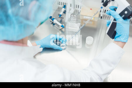 Scienziato in lab conducendo esperimenti biotecnologici Foto Stock
