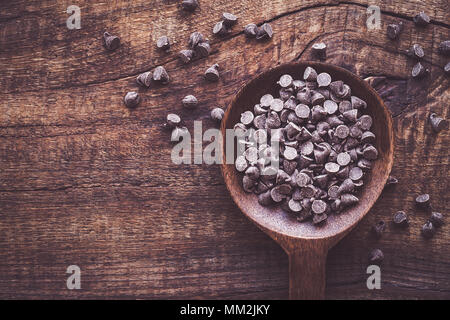 Dark cholocale bocconcini in una ciotola contro scuri in legno rustico sfondo Foto Stock