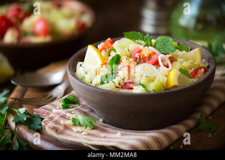 Tabulé vegetariano - deliziosa cuscus con insalata di pomodori ciliegini, cetrioli, menta fresca e foglie di prezzemolo. Foto Stock