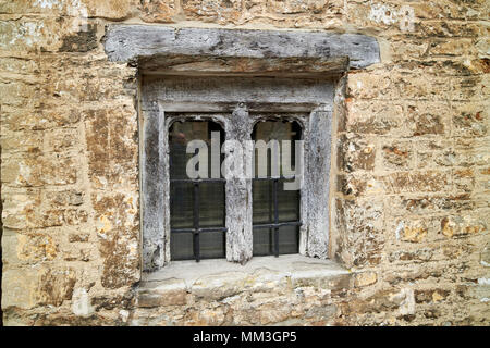 Storico antico legno di piccole dimensioni finestra incorniciata nella costruzione di mattoni il villaggio di Castle Combe Wiltshire, Inghilterra Regno Unito Foto Stock