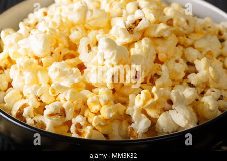 Gustosa popcorn con il formaggio Cheddar e il parmigiano in una ciotola macro sul tavolo orizzontale. Foto Stock