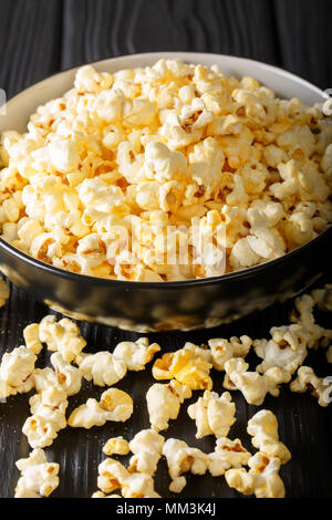 Deliziosi popcorn di formaggio in una ciotola di close-up su una tavola verticale. Foto Stock