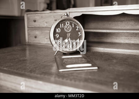 Antica scrivania con sveglia e passaporto britannico, nome tranciati, in seppia Foto Stock
