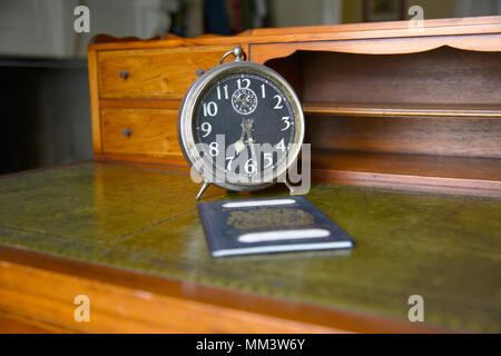 Antica scrivania con sveglia e passaporto britannico, nome tranciati Foto Stock
