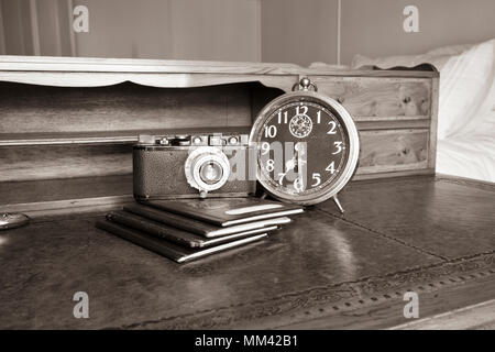 Legni antichi scrivania con passaporti e vintage leica II a partire dal 1932, orologio vintage, nomi sul passaporto tranciati, in seppia Foto Stock
