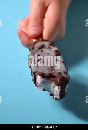 Mano che regge il morso di gelato Foto Stock
