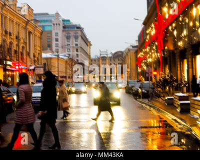 Le luci di Natale, le decorazioni di Natale sulla strada. sfondo sfocato strada di città con luminarie di Natale. le vetture su strada Foto Stock