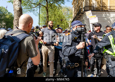 La Metropolitan Police poliziotti scortare prominente altoparlante musulmano Muhammad Hijab lontano da una libertà di parola rally, London, Regno Unito Foto Stock