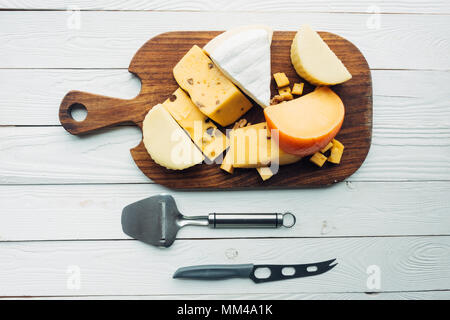 Un assortimento di tipi di formaggio e posate Foto Stock