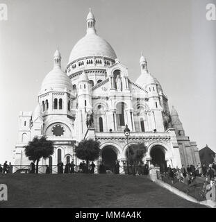 Anni '50, immagine storica della Basilica del Sacro cuore di Parigi, più comunemente conosciuta semplicemente come Sacre-Coeur una chiesa cattolica romana costruita sulla cima della collina di Montmartre, Parigi, Francia. Questo monumento iconico è stato consacrato nel 1919 ed è il secondo edificio religioso più visitato di Parigi. Foto Stock