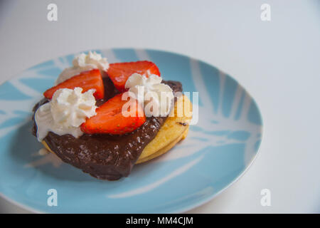 Pancake con cioccolato, fragole e panna. Foto Stock