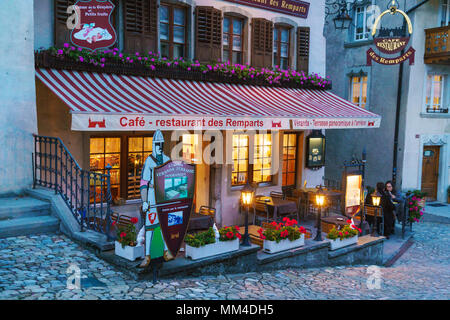 Gruyeres, Svizzera - 18 Ottobre 2017: i ristoranti e le caffetterie della città vecchia al crepuscolo Foto Stock