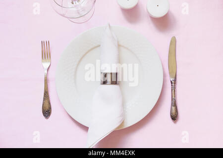 Tabella di impostazione posto sulla rosa tovaglia di lino. Vista dall'alto. Concetto. Foto Stock