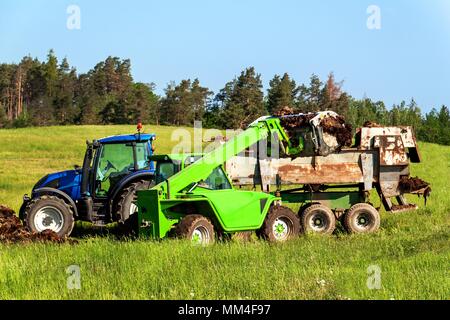 Il concime naturale agro bio la fecondazione. Concime di carico sul trattore. Il paesaggio agricolo nella Repubblica Ceca Foto Stock