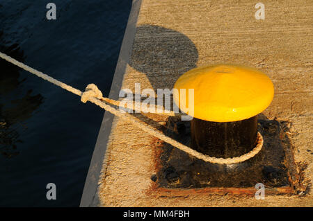 Gancio di ormeggio e pressanti fune sul molo Foto Stock