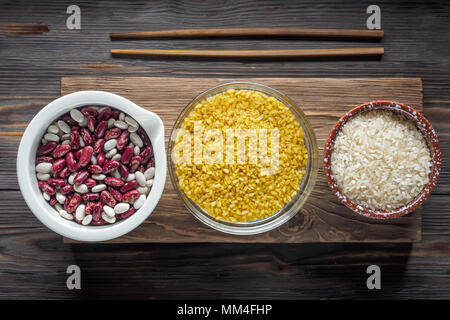 Impostare tradizionale Organica Vegana ingrediente alimentare Super in Medio Oriente cucina Asiatica cereali mescolare fagioli bianchi e rossi di bulgur riso culinaria in legno cucchiai bo Foto Stock