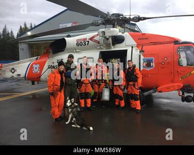 Un Coast Guard MH-60 elicottero Jayhawk equipaggio, distribuito a Cordova, raccoglie con due persone e un cane che ha salvato dopo i diportisti kayaked a Montague Island, Alaska, quando loro 34-piede nave cominciò a prendere su acqua, Sett. 8, 2017. L'equipaggio del guardacoste Chandeleur salvò due cani che sono rimasti sulla nave. Stati Uniti La guardia costiera della foto Foto Stock